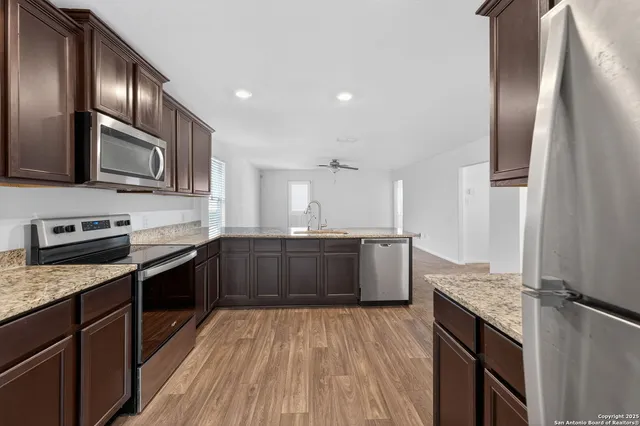 a kitchen with stainless steel appliances granite countertop a refrigerator a stove top oven a sink and dishwasher