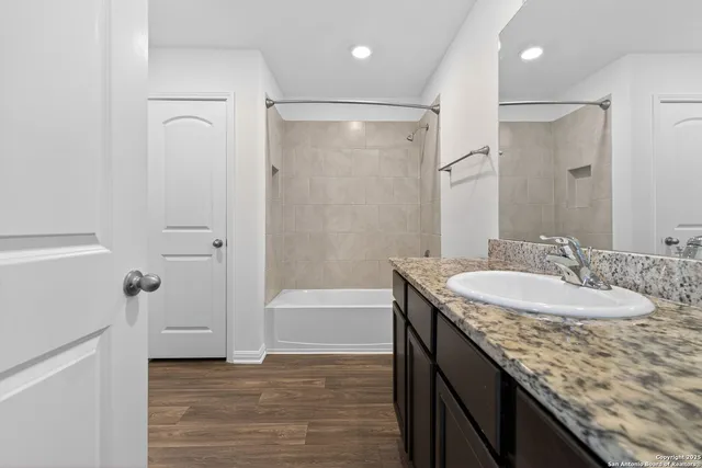 a bathroom with a granite countertop sink a toilet and shower
