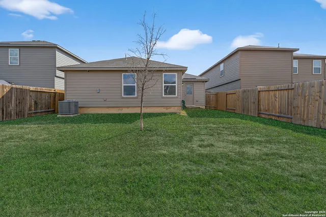 a view of a backyard with a barbeque and wooden fence