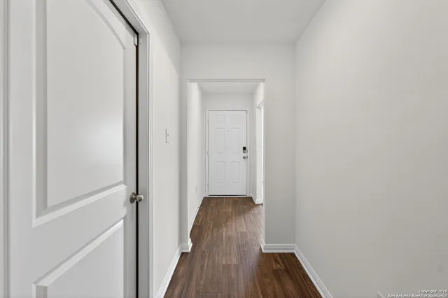 a view of a hallway with wooden floor