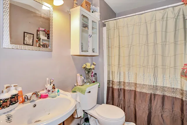 a bathroom with a toilet a sink and a mirror