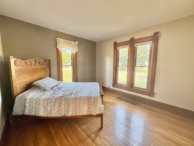 a bedroom with a bed and a large window
