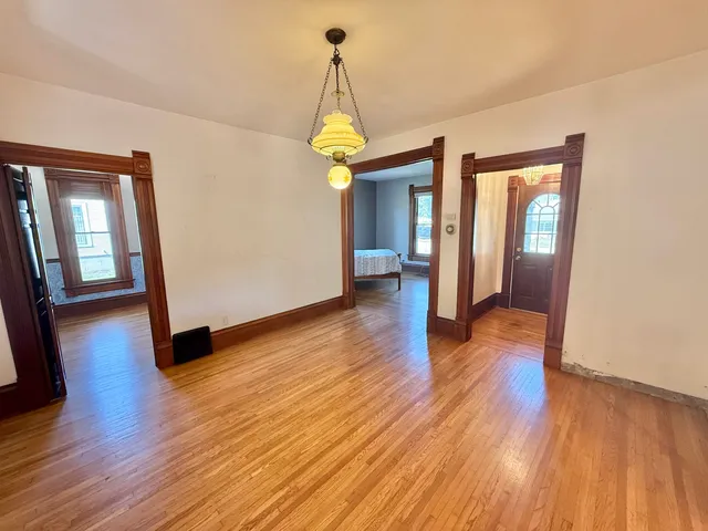 a view of a hallway with wooden floor and stairs