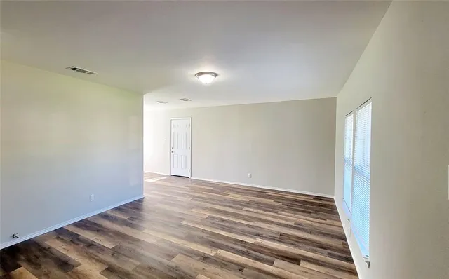 a view of an empty room with wooden floor