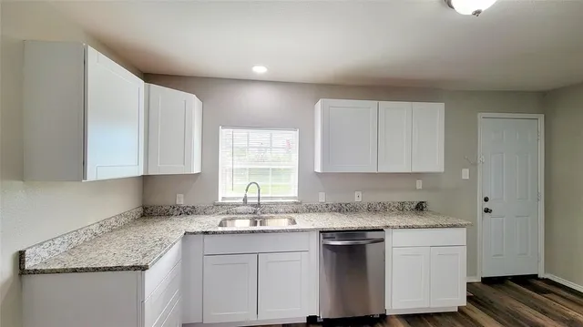 a kitchen with granite countertop cabinets sink and window
