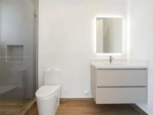 a bathroom with a toilet sink and a mirror