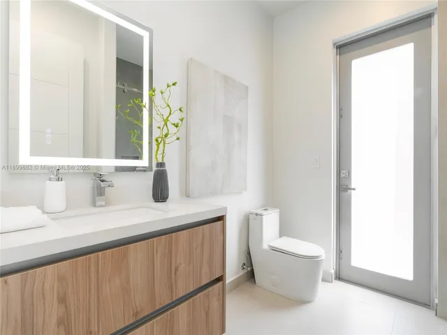 a bathroom with a granite countertop sink a toilet and a mirror