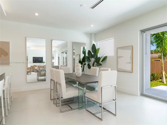a dining room with furniture and a potted plant