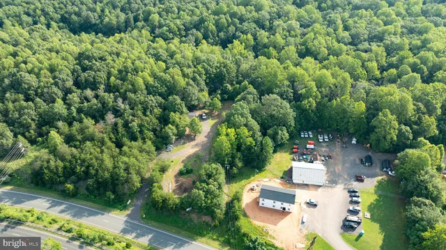 an aerial view of residential house with outdoor space and trees all around