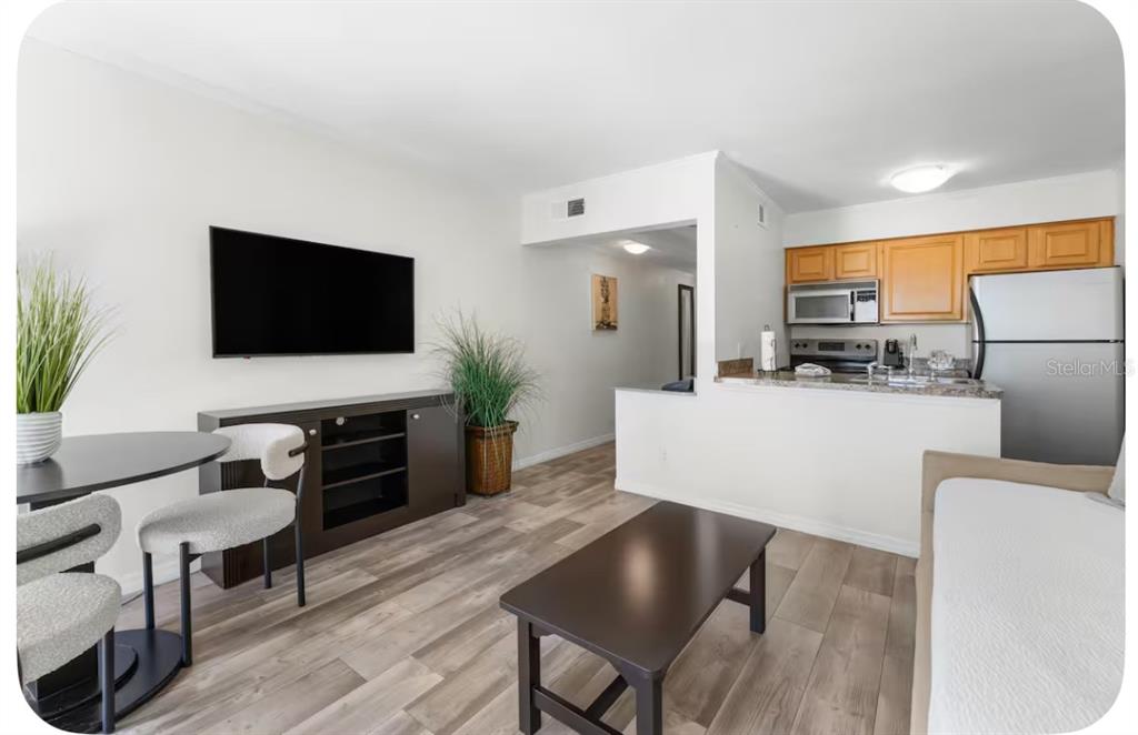 2506 North Rocky Point Drive, Unit 209 Tampa, FL 33607 - Photo 4 of 12 a living room with furniture and a flat screen tv