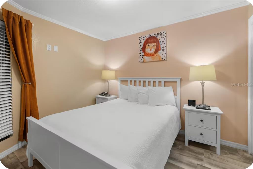 2506 North Rocky Point Drive, Unit 209 Tampa, FL 33607 - Photo 5 of 12 a bedroom with a bed and a flat tv screen on dresser