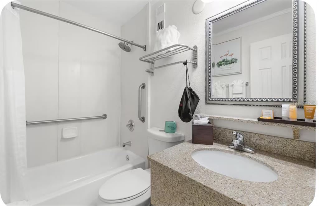 2506 North Rocky Point Drive, Unit 209 Tampa, FL 33607 - Photo 8 of 12 a bathroom with a granite countertop sink toilet and shower