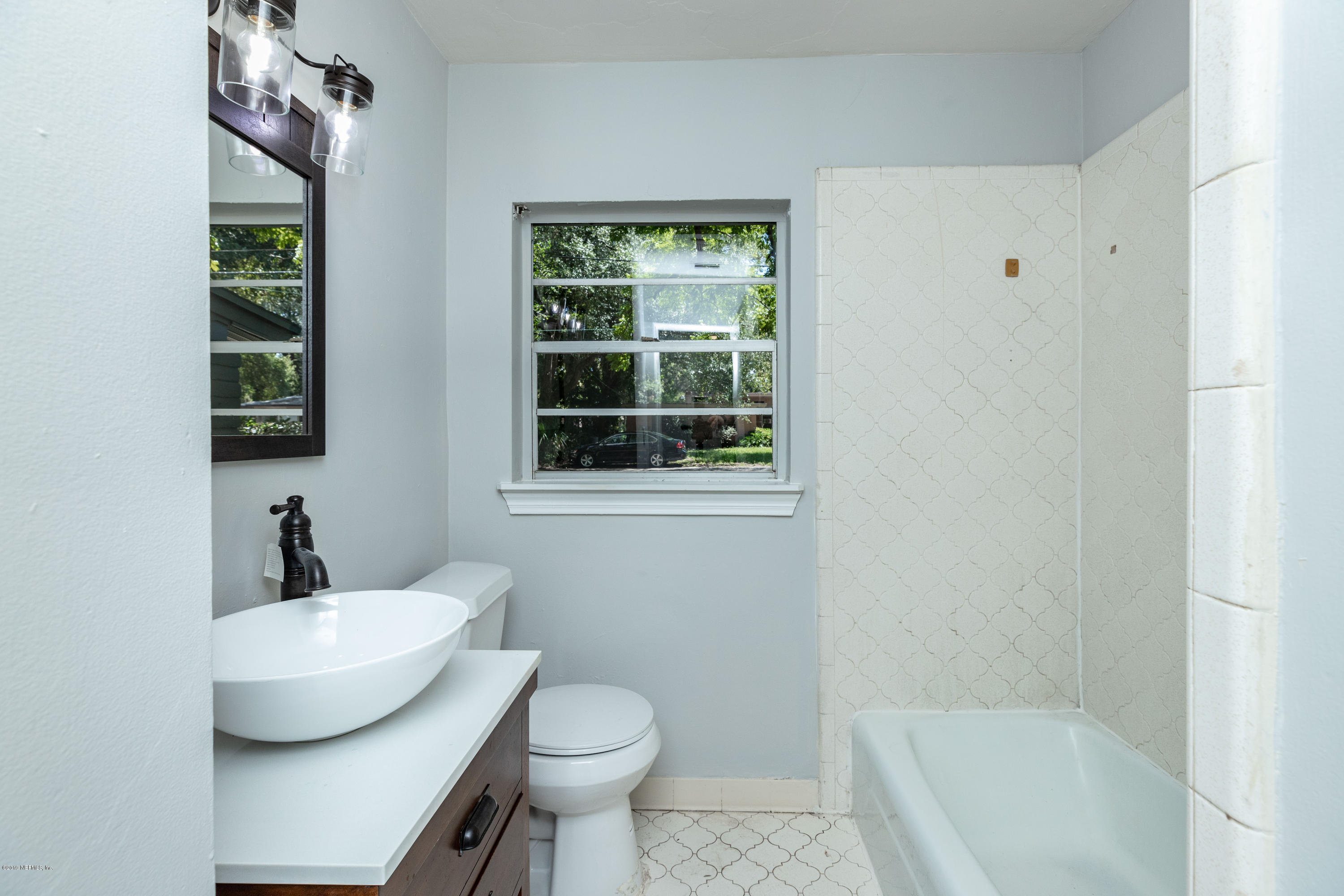 5318 South River Road Jacksonville, FL 32211 - Photo 11 of 32 a bathroom with a sink toilet a mirror and shower