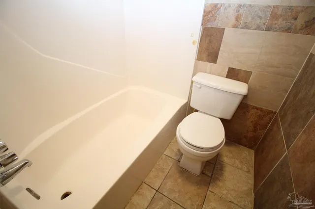 a white toilet sitting next to a white sink