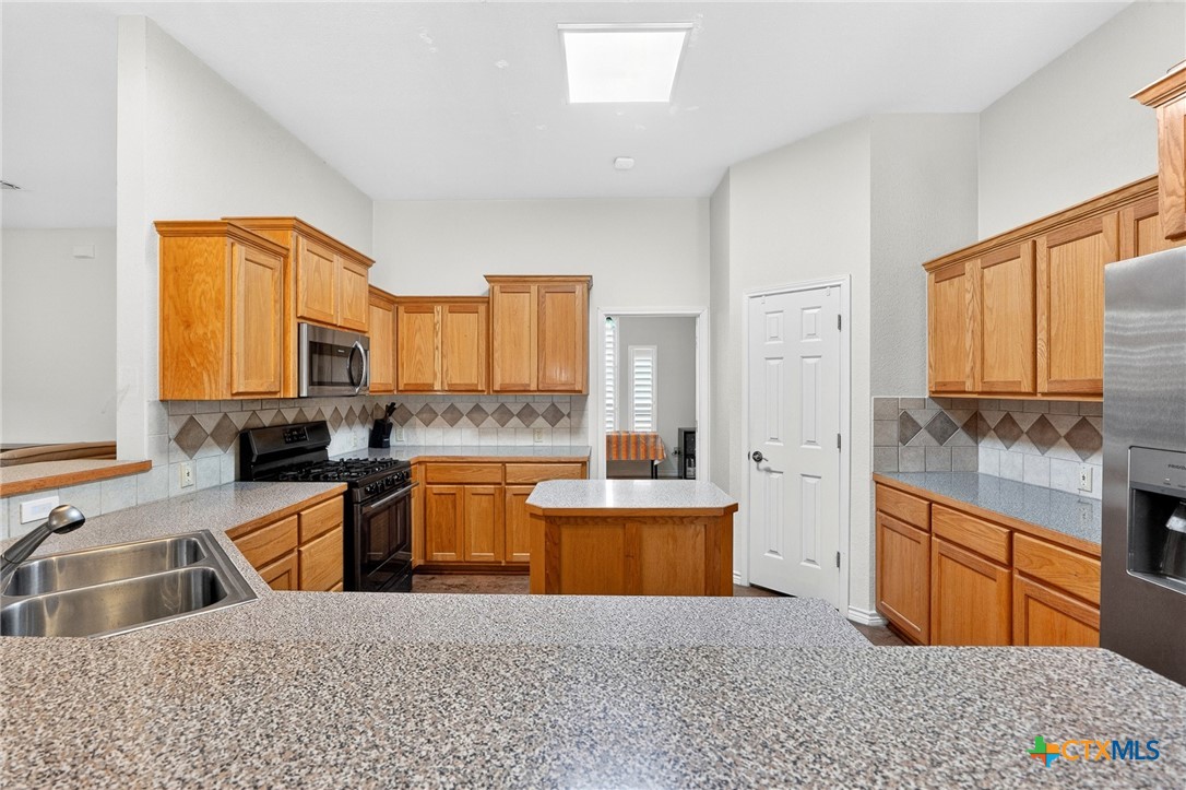 421 Sunset Ridge Drive Killeen, TX 76549 - Photo 24 of 47 a kitchen with granite countertop a sink dishwasher stove and cabinets