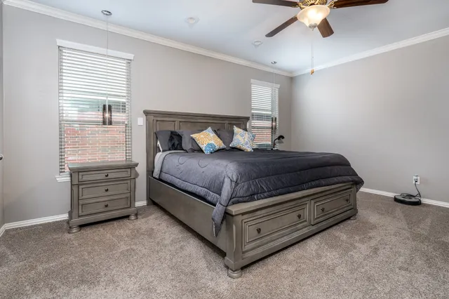 a bed room with a bed and a ceiling fan