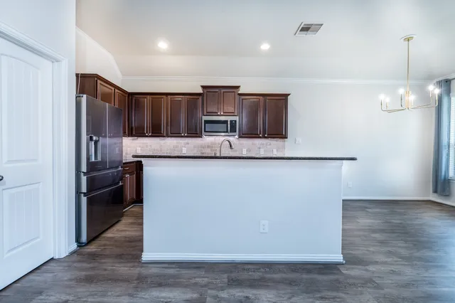 a kitchen with kitchen island a counter top space a sink and appliances