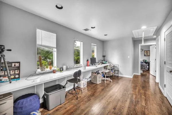 a room with lots of wooden furniture a large window appliances and furniture