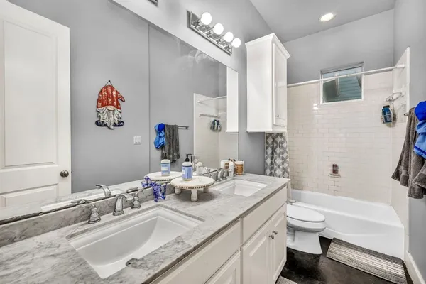 a bathroom with a granite countertop sink a toilet and a bathtub