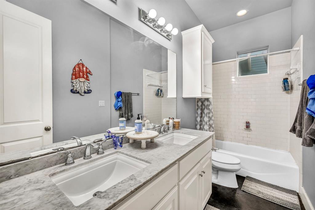 4517 Depew Avenue Austin, TX 78751 - Photo 19 of 20 a bathroom with a granite countertop sink a toilet and a bathtub