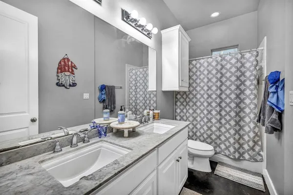 a bathroom with a sink vanity mirror and toilet