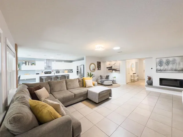 a large white kitchen with a refrigerator a stove a microwave oven with white cabinets and granite countertops