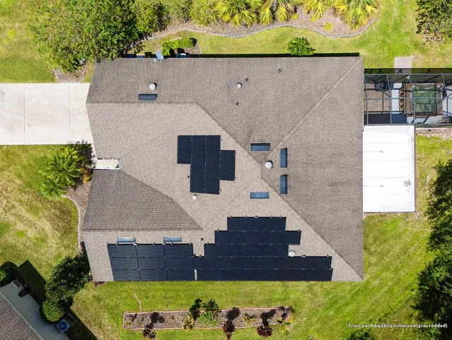 a aerial view of a house with a yard table and chairs