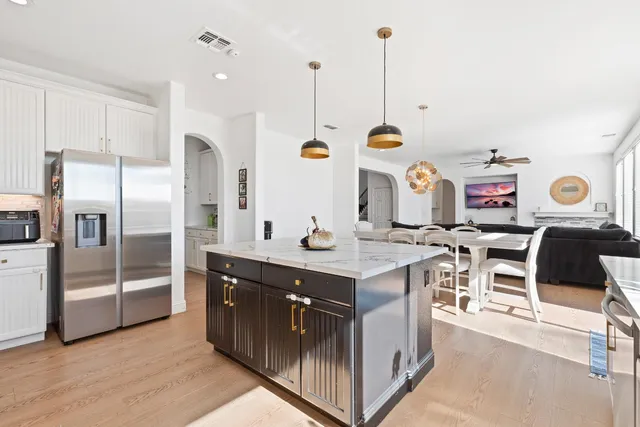 a kitchen with kitchen island granite countertop a sink a counter top space and stainless steel appliances