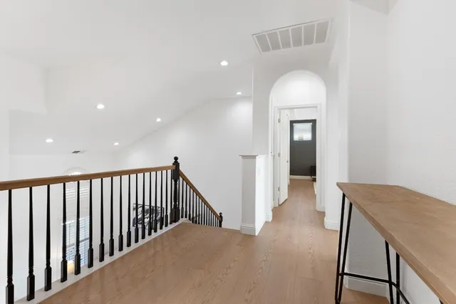 a view of a hallway with entryway and wooden floor