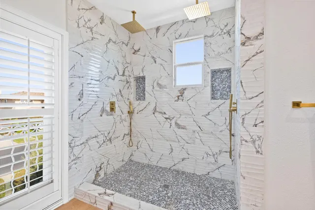 a bathroom with a double vanity sink mirror and shower