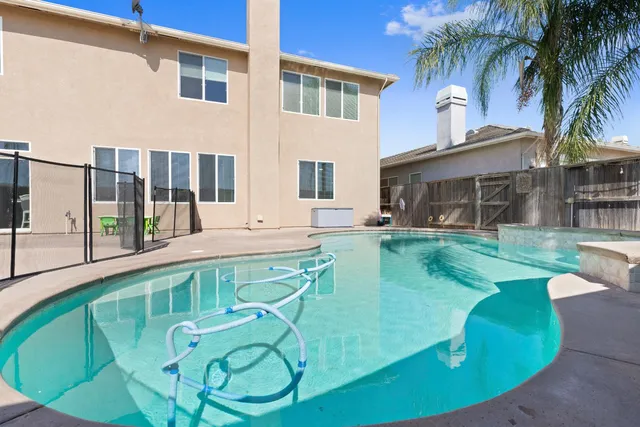 a view of a house with swimming pool and sitting area