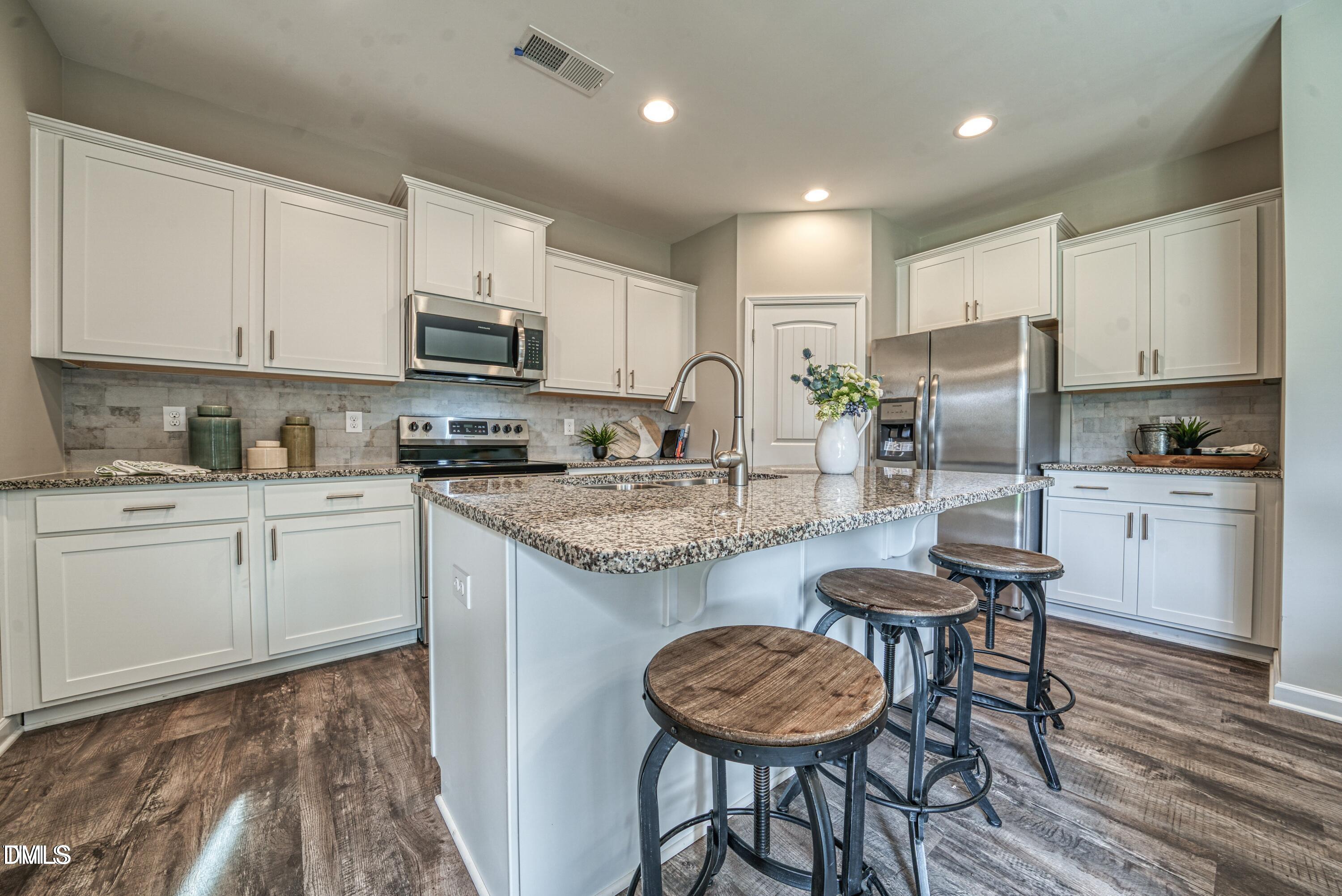 2304 Broad Street Durham, NC 27704 - Photo 3 of 39 a kitchen with granite countertop kitchen island cabinets and refrigerator