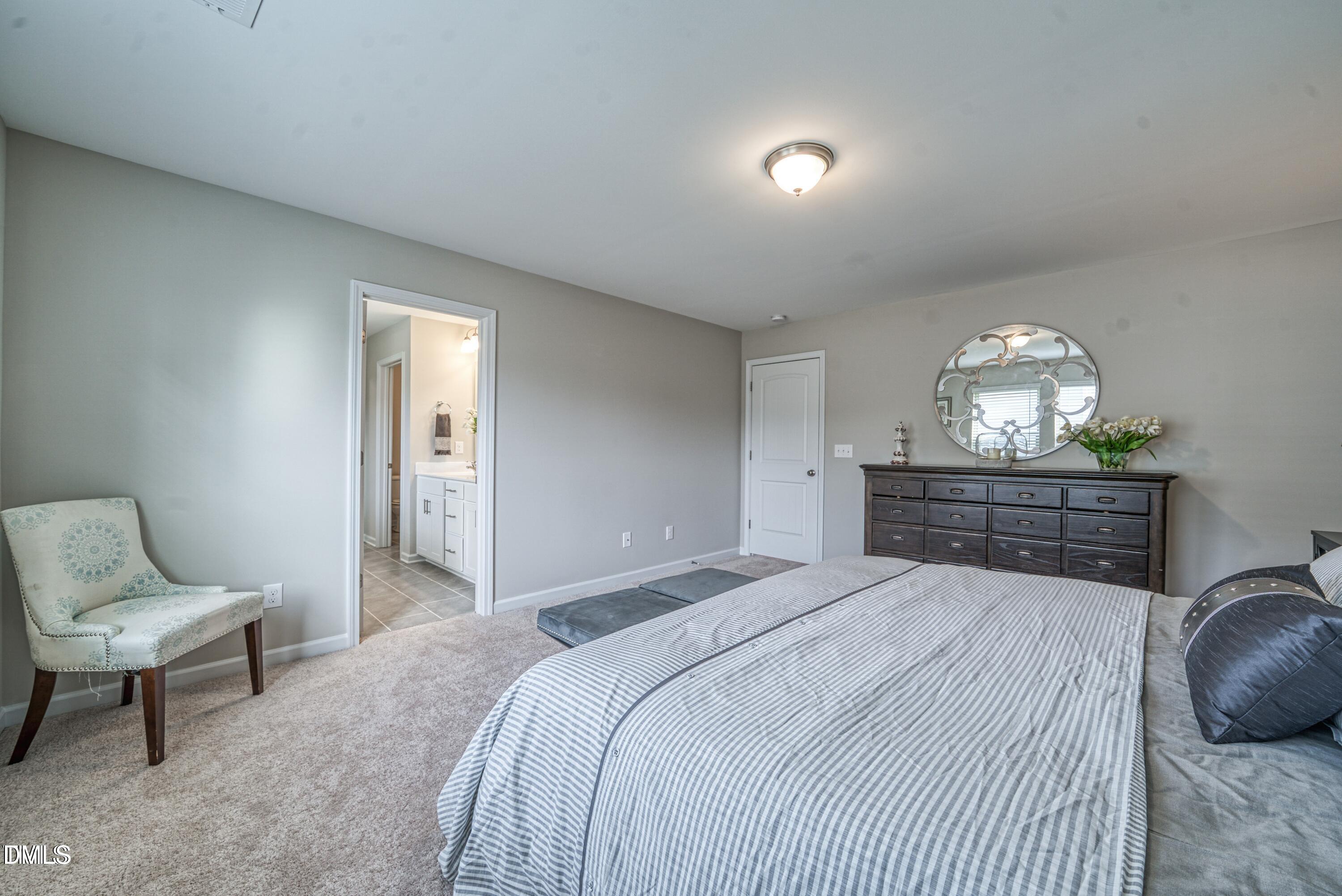 2304 Broad Street Durham, NC 27704 - Photo 35 of 39 a spacious bedroom with a bed and a chair