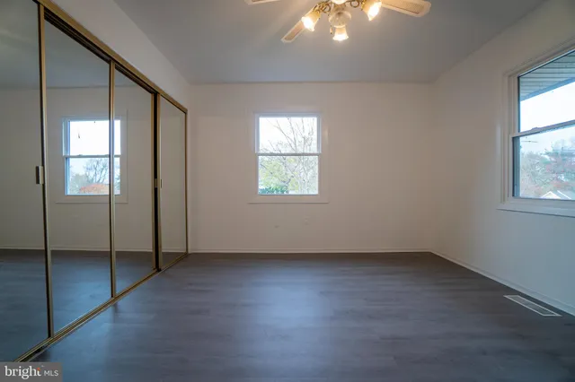 an empty room with windows and closet