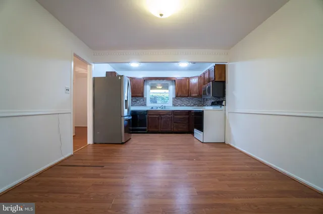 a view of a kitchen with wooden floor and electronic appliances