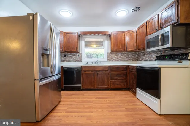 a kitchen with stainless steel appliances granite countertop a refrigerator and a stove top oven