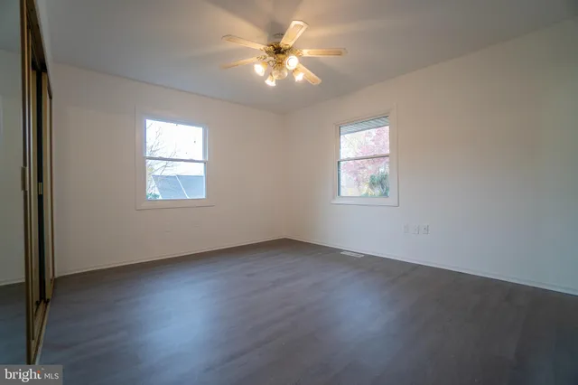 a view of an empty room window and wooden floor