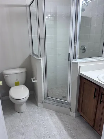 an empty room with wooden floor a chandelier fan and windows
