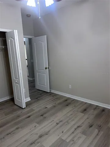 a view of a hallway with wooden floor and closet