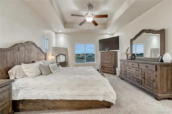 a bedroom with a large bed and a flat tv screen on dresser