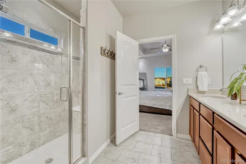 a bathroom with a granite countertop sink a mirror and a shower