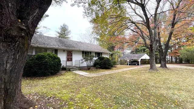 a view of a house with a yard covered in snow
