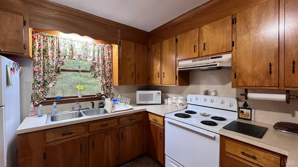 a kitchen with kitchen island granite countertop a sink cabinets and wooden floor