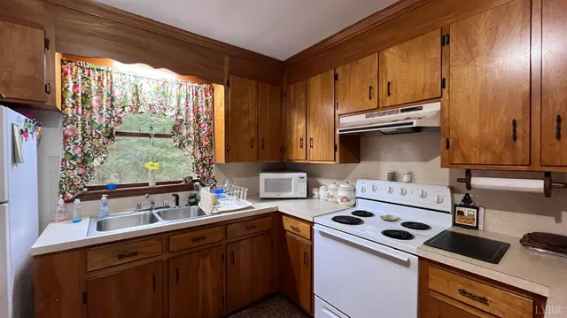 a kitchen with kitchen island granite countertop a sink cabinets and wooden floor