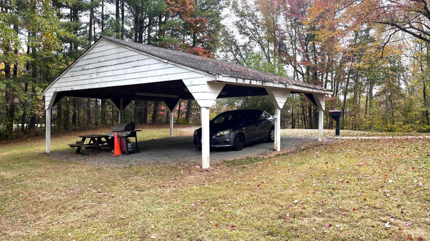 1091 Acorn Road Nathalie, VA 24577 - Photo 24 of 29 a view of a wooden house with a large trees and cars