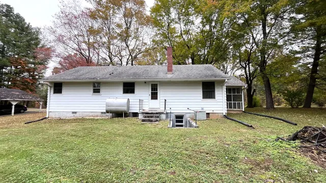 a backyard of a house with table and chairs