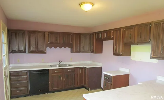 a kitchen with kitchen island granite countertop wooden cabinets a sink and dishwasher