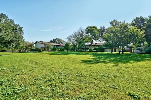 a view of a grassy field with trees