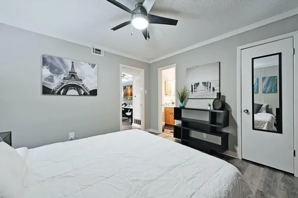 a bedroom with a large bed and a chandelier