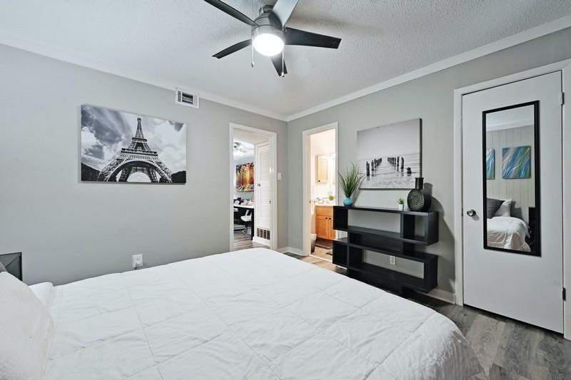 711 Eberhart Lane, Unit 202 Austin, TX 78745 - Photo 4 of 7 a bedroom with a large bed and a chandelier